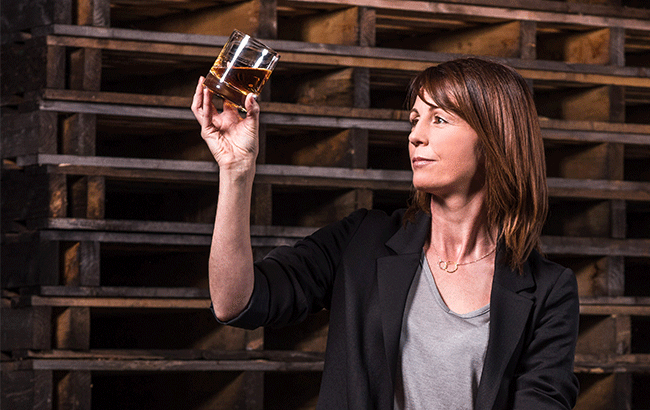 The new master blender of Bushmills holds a glass of whiskey