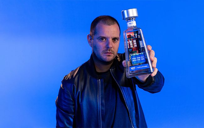 Mike Skinner holding his limited edition designed bottle for 1800 Tequila