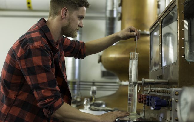 A man watches a spirits safe at a whiskey distillery