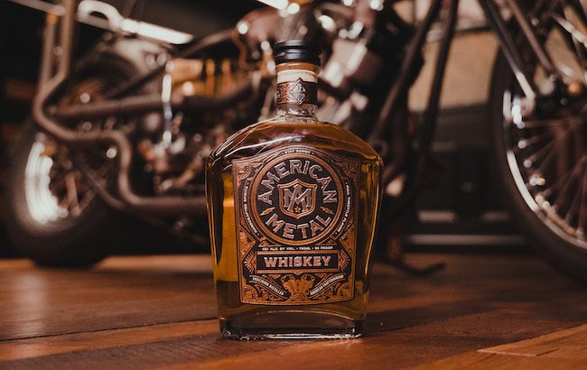 A bottle of whiskey in front of a motorcycle