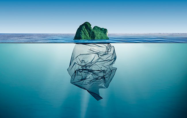 plastic packaging – garbage plastic with island floating in the ocean.