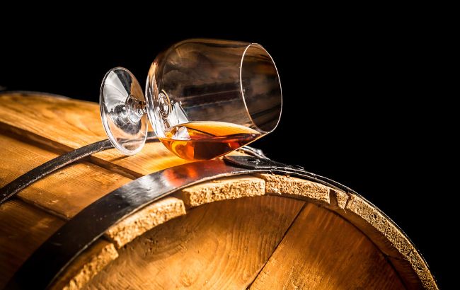 Cognac in a glass on a barrel