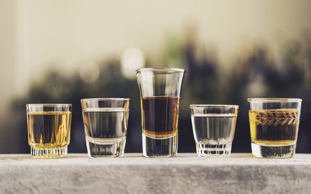 Five shot glasses filled with a variety of alcohol