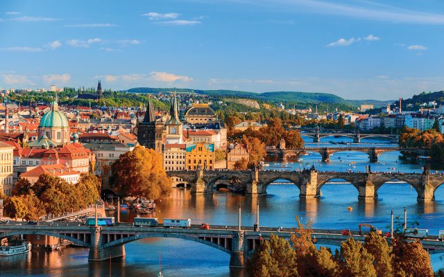 View of the Vltava River and Charle bridge with red foliage, Prague, Czech Republic, in Eastern Europe