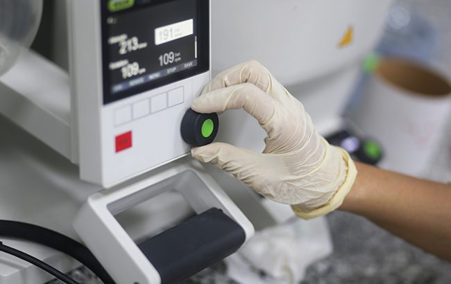 Closeup of a hand of woman scientist operating a rotary evaporator to make an experiment in the laboratory