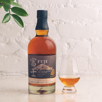 A bottle of Fuji 50th anniversary single malt next to a glencairn glass of whisky