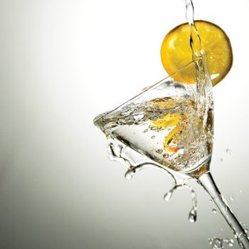 glass of gin martini with olive and splash