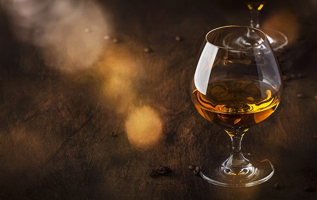 Armagnac, French grape brandy, strong alcoholic drink. Still life in vintage style with cigar smoke, copy space