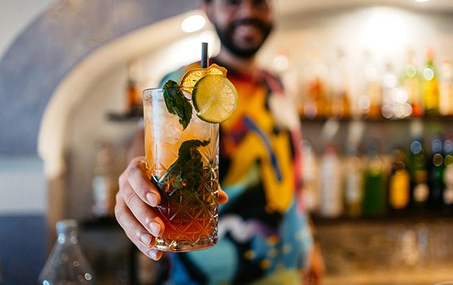 Bartender serving a rum cocktail drink at a bar in Malta.