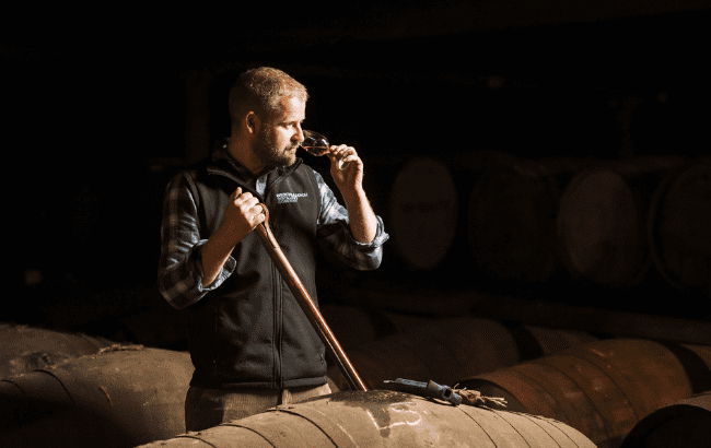 Adam Hannett nosing a whisky from a barrel at Bruichladdich