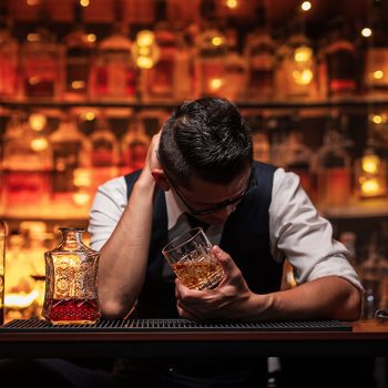Bartender is pouring whiskey into a customer's glass